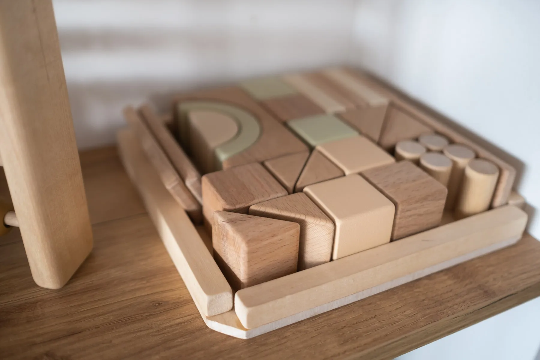 A tray of wooden building blocks on a classroom shelf